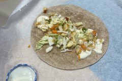 De wrap wordt belegd met groente, fruit en saus naar smaak